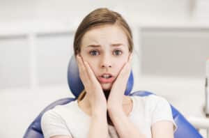 scared and terrified patient girl at dental clinic office