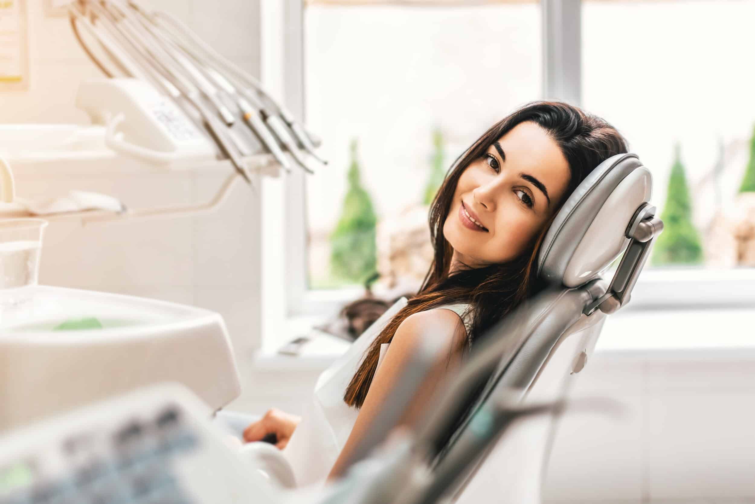 A woman sitting in a dentist’s chair and smiling